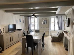 a living room with a dining table and a tv at Le CROISIC Centre Historique in Le Croisic
