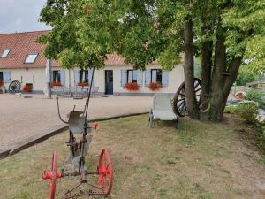 an old tractor and a chair in front of a building at Au chemin du paradis Gîte de 10 personnes 4 Etoiles in Saint-Martin-lez-Tatinghem