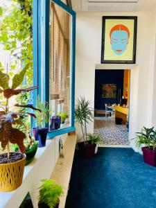 a room with potted plants on the floor and a window at Communa Good Vibes in Tbilisi City +54 photos