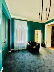 ein Wohnzimmer mit einem Sofa und einer blauen Wand in der Unterkunft Communa Good Vibes in Tbilisi City + 75 Fotos