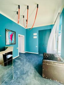 ein Wohnzimmer mit blauen Wänden und einer Couch in der Unterkunft Communa Good Vibes in Tbilisi City