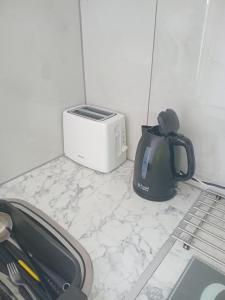 a tea kettle and a toaster sitting on a counter at Cosy Studio Flat-Just Renovated-Free Street Parking & Independent Entrance in Hanworth