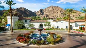 Un complejo turístico con una fuente en medio de una carretera con montañas. en LV034 Cozy Upstairs Legacy Villas Suite, en La Quinta