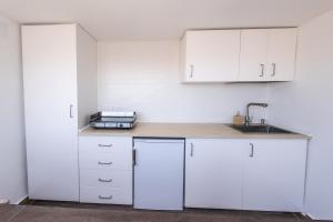 Una cocina blanca con gabinetes blancos y un fregadero. en Casa Principe Old Town Marbella by PRINCIPE1, en Marbella