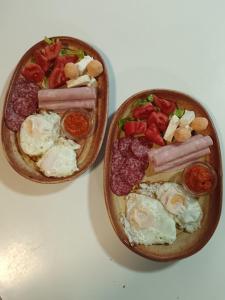 two bowls of food with eggs sausage and tomatoes at Etno selo Dukat in Belo Polje