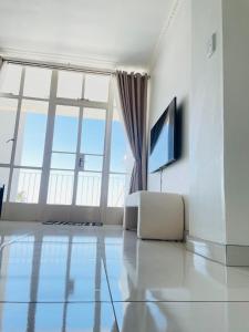 a living room with a large window and a television at Villa Saarchi Apartments in Windhoek