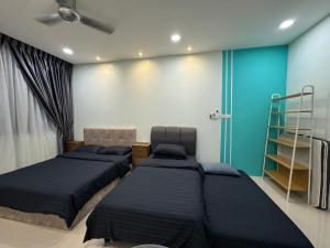 クチンにあるKuching Cozy Comfort 01 - Riverine Diamond Kuching 4 Paxの青い壁の部屋にベッドが2つある +25枚の写真