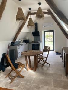 a kitchen with a table and chairs in a room at Paradis Secret -Bain et Sauna NORDIQUE in Saint-Chels