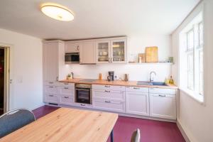 a kitchen with white cabinets and a wooden table at Alandblick Gasthaus in Wanzer +61 photos