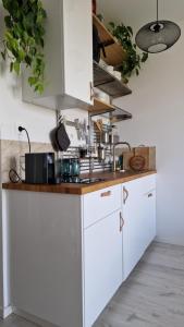 a kitchen with white cabinets and a wooden counter top at Cozy one-room apartment with garage and AC in Bratislava