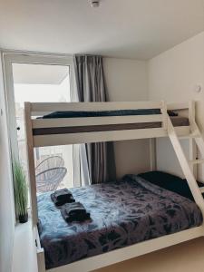 オーステンデにあるLuxe d’Oの二段ベッド2台と窓のある寝室