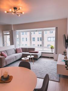 una sala de estar con un sofá y una mesa en Vitamin Sea, in het centrum en naast de zee, en Ostende