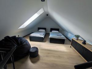 WojcieszyceにあるDomki Karkonosze Pod Dębemの屋根裏部屋 ベッド2台&ソファ付