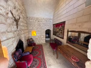 a room with a stone wall with a couch and a mirror at Sikeft Otel in Midyat