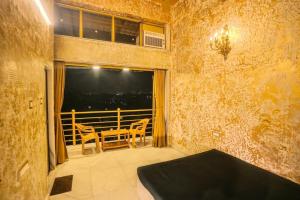 a room with a balcony with a table and chairs at Wadhwani's Haveli villa in Royal Palms in Mumbai