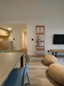 Una sala de estar con sillas, una mesa y un televisor. en Temporalias BRC, en San Carlos de Bariloche