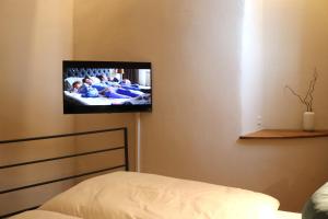 een kamer met een tv aan de muur en een bed bij Charmantes Chateau Lichter - Alte Schmiede in Ließem