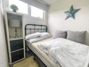 a small bedroom with a bed with a star on the wall at Lovely 4 Berth Chalet At Cedar Springs Park In Heacham, Norfolk Ref 92031Cs in Heacham