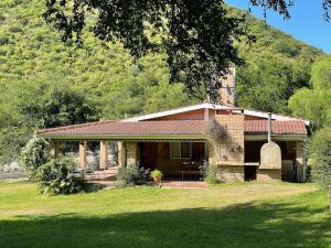 ein kleines Backsteinhaus vor einem Berg in der Unterkunft Casa Entera in Cordoba