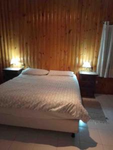 ein Schlafzimmer mit einem weißen Bett und zwei Nachttischen in der Unterkunft Casa Entera in Cordoba + 9 Fotos