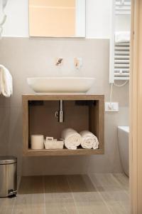 Un baño con lavabo y estante con toallas. en Roxy luxury house Rome, en Roma