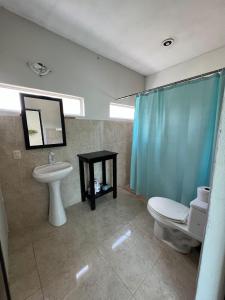 a bathroom with a sink and a toilet and a mirror at Casa Iguana hotel boutique in El Cuyo +51 photos