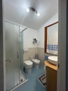 a bathroom with a toilet and a sink and a shower at Villa Orsola in Chia