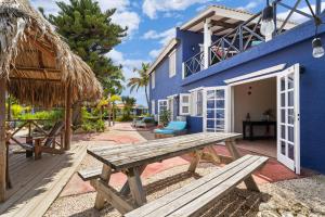 a blue house with a wooden bench in front of it at Blachi Koko Apartments in Kralendijk