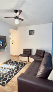 ein Wohnzimmer mit einer Couch und einem Deckenventilator in der Unterkunft Apartamento no CENTRO de Caraguatatuba. in Caraguatatuba