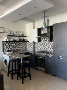 a kitchen with a sink and a table with stools at Oasis de détente in Agadir