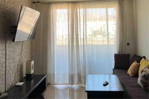 a living room with a couch and a large window at Oasis de détente in Agadir