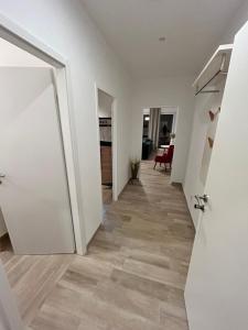 ロープベにあるAuf Feiningers Spuren durch das Mönchgut Apartment 2の白い壁と木の床の廊下 +4枚の写真