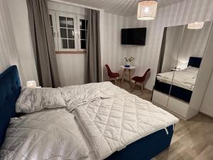 ロープベにあるAuf Feiningers Spuren durch das Mönchgut Apartment 2のベッドとテーブルと椅子のある寝室