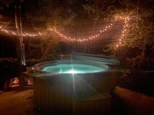 Saint-ChelsParadis Secret -Bain et Sauna NORDIQUE的院子里有按摩浴缸,还有圣诞彩灯