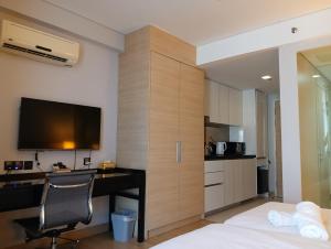 a bedroom with a desk with a computer and a tv at The Straits Suites by Ciconia in Malacca
