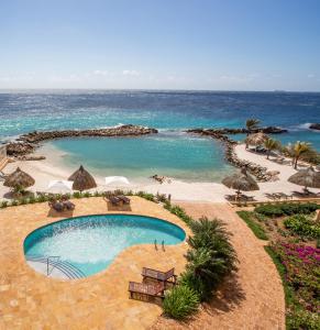 a swimming pool next to a beach with the ocean at The Strand - The Beach, Penthouse 4A in Willemstad