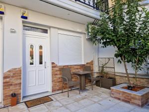 eine Terrasse mit einem Tisch und Stühlen neben einer Tür in der Unterkunft Aigaiou House 2 in Thessaloniki