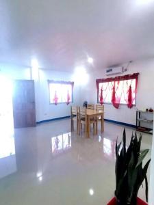a living room with a table and chairs in it at House with Sunrise&Beach view in Candaping B +3 photos