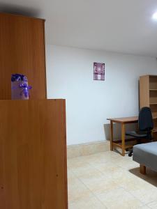 a room with a bed and a desk and a table at Apartment Gray in Pirot