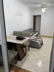 Apartamento Aviação PG في برايا جراندي: غرفة معيشة بها أريكة وطاولة +11 صورة