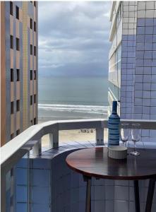 Apartamento Aviação PG في برايا جراندي: طاولة على شرفة مطلة على الشاطئ