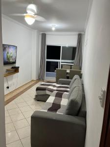 Apartamento Aviação PG في برايا جراندي: غرفة معيشة بها سريرين وأريكة