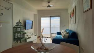 a living room with a blue couch and a table at Sea of Dreams in Villajoyosa