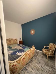 a bedroom with a bed and a chair at Appartement en lisière de forêt in Wingen-sur-Moder