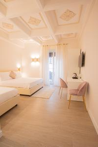 Un dormitorio con dos camas y un escritorio y una silla. en Roxy luxury house Rome, en Roma