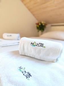 a towel sitting on top of a bed at Relax Houses - Domy Mazur in Małkinie