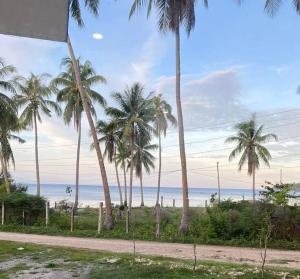 a group of palm trees on a beach with the ocean at Blue Haven with beach view in Candaping B +4 photos