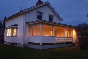 a white house with large windows on the side of it at Stor villa på Teg i Umeå, nära centrum med parkering in Umeå