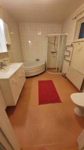 a bathroom with a tub and a sink and a shower at Stor villa på Teg i Umeå, nära centrum med parkering in Umeå