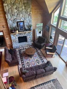 een woonkamer met een stenen open haard bij Welcome to Bear's Den Lodge in Round Lake Seaplane Base